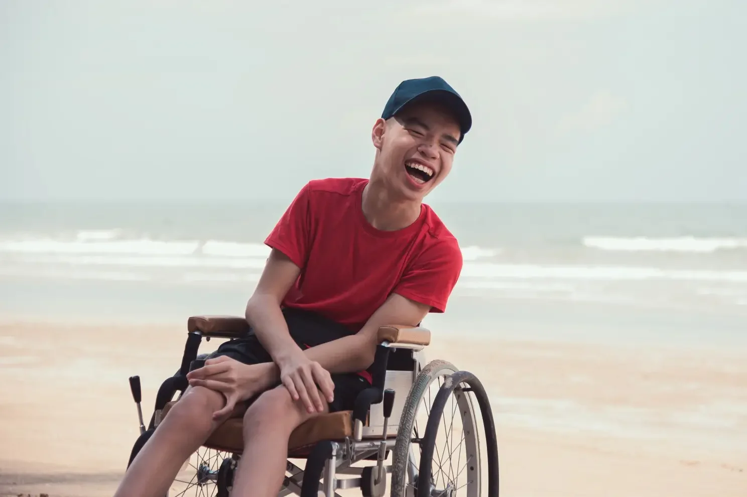 Disabled man laughing at beach