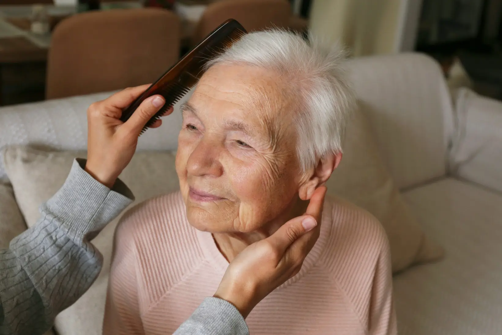 Elderly woman having her hair combed